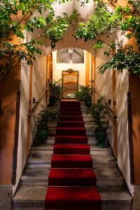 The grand entrance staircase at Palazzo De Gregorio, a historic family palazzo in Palermo.